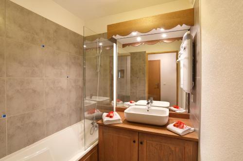 La salle de bains est pourvue d'un lavabo et d'un miroir. dans l'établissement Résidence Néméa Le Grand Ermitage, à Châtel