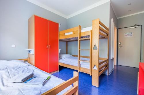 a bedroom with two bunk beds with red cabinets at martas Gästehäuser Hauptbahnhof Berlin in Berlin
