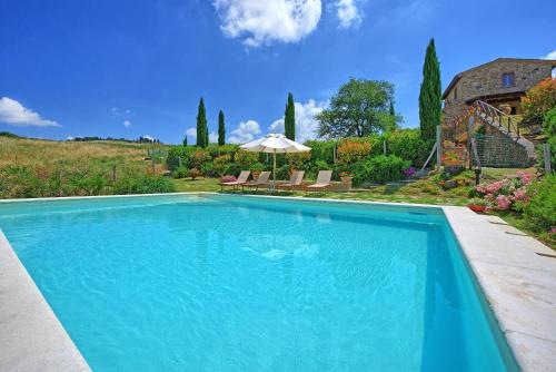 a swimming pool in a yard with a house at Castelmuzio by PosarelliVillas in Castelmuzio