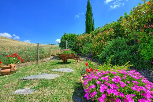 a garden with flowers and a bench on a hill at Castelmuzio by PosarelliVillas in Castelmuzio
