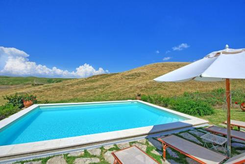 a swimming pool with an umbrella and a table and chairs at Castelmuzio by PosarelliVillas in Castelmuzio