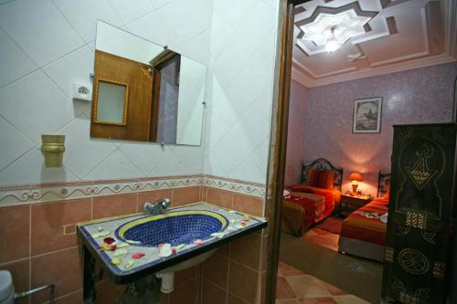 a bathroom with a sink and a bedroom at Riad Taghazoute in Marrakesh