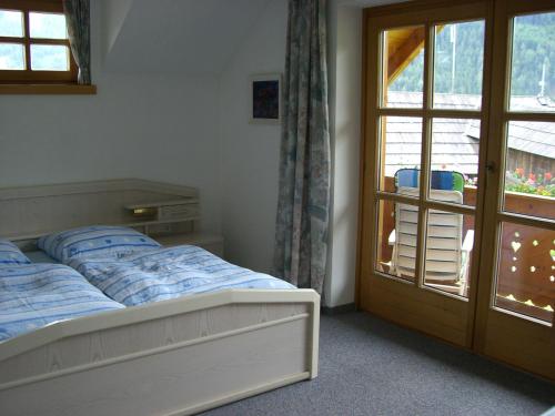 ein Schlafzimmer mit einem Bett und einer Glasschiebetür in der Unterkunft Werner Hinteregger in Bad Kleinkirchheim