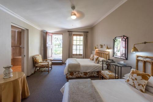 Habitación de hotel con 2 camas y baño en Lord Milner Hotel, en Matjiesfontein