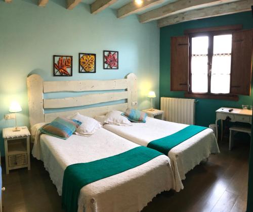a bedroom with two beds and two windows at Casa Rural Zigako Etxezuria in Ziga