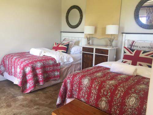 a bedroom with two beds and a mirror at KarMichael Farm in Himeville
