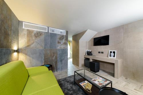 a living room with a green couch and a tv at Just Hotel Milano in Milan
