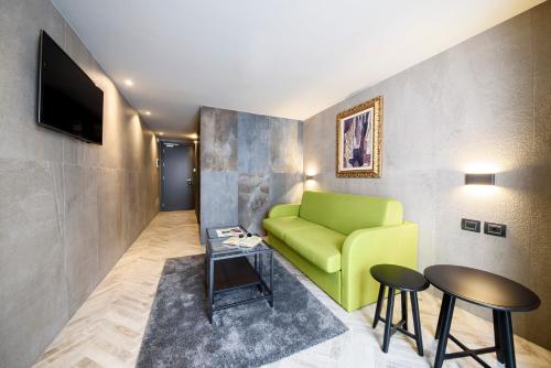 a living room with a green couch and two tables at Just Hotel Milano in Milan