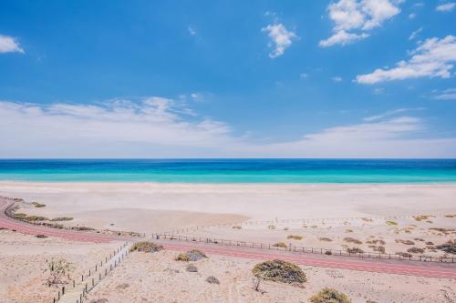
a sandy beach with a view of the ocean at Iberostar Selection Fuerteventura Palace in Morro del Jable
