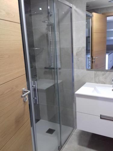a glass shower in a bathroom with a sink at Casa Tras Do Rio in Coles