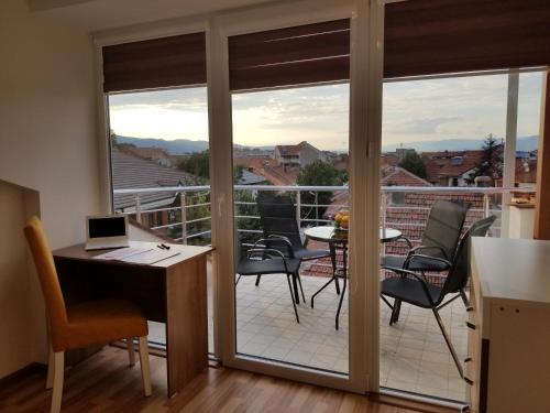 a kitchen with a balcony with a table and chairs at Sky Apartments in Strumica