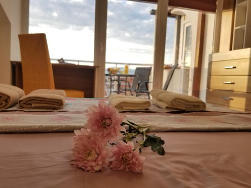 a room with three beds with pink flowers on a table at Sky Apartments in Strumica
