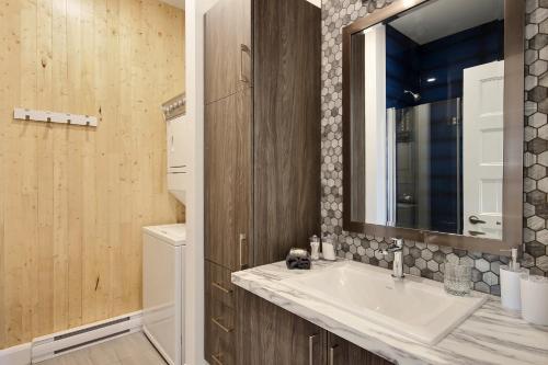 a bathroom with a sink and a mirror at The Modern Cocoon in Quebec City