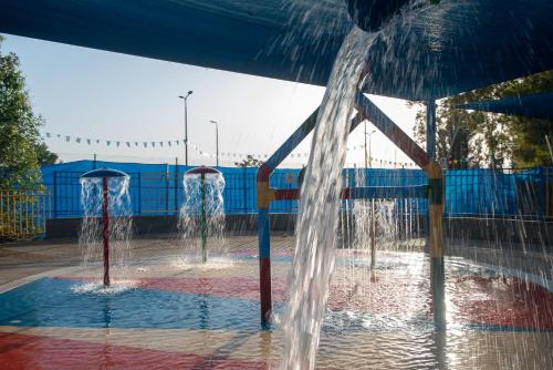 two water fountains in a swimming pool at Kinar Galilee in Kinar