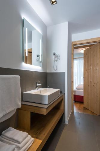 a bathroom with a sink and a mirror at Catrina Apartments in Disentis