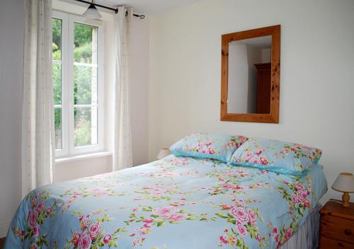ディナンにあるVal Rive - Sisley Apartmentのベッドルーム1室(花柄の掛け布団、鏡付)