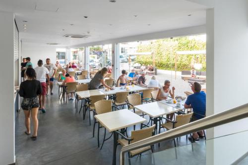 a group of people sitting at tables in a restaurant at Vila Recife Hotel in Albufeira