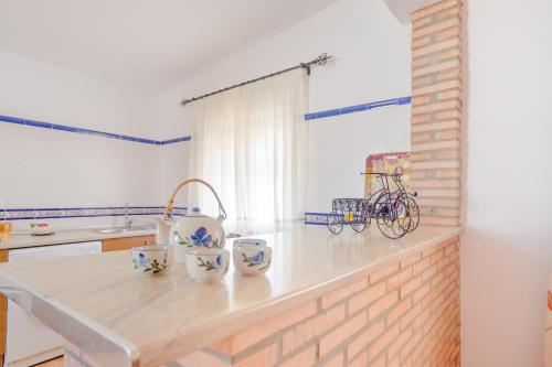 una cocina con una barra con una bicicleta. en Casa Mariana en Conil de la Frontera