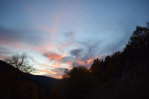 a sunset in the sky with trees in the foreground at Kellnerhof in Nova Levante