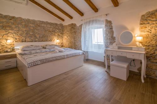 ein Schlafzimmer mit einem Bett, einem Waschtisch und einem Waschbecken in der Unterkunft Apartments Tara in Vrbnik
