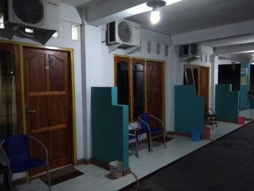 a room with chairs and tables and a tv on the wall at Dasi Guesthouse in Ende