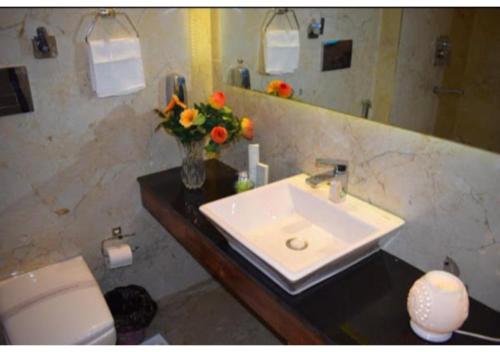a bathroom with a sink and a vase of flowers at Exotic Kufri stay with Incredible Views in Kūfrī
