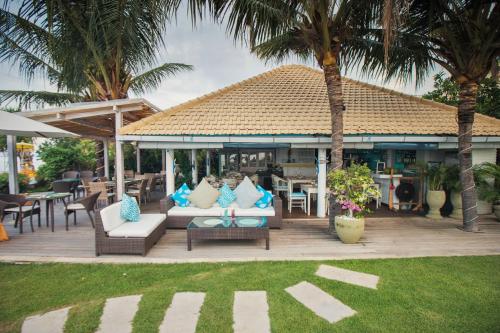 a patio with couches and tables and palm trees at Mayo Resort in Umeanyar