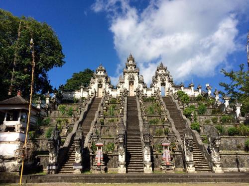 a large white building with stairs and grass at Mayo Resort in Umeanyar