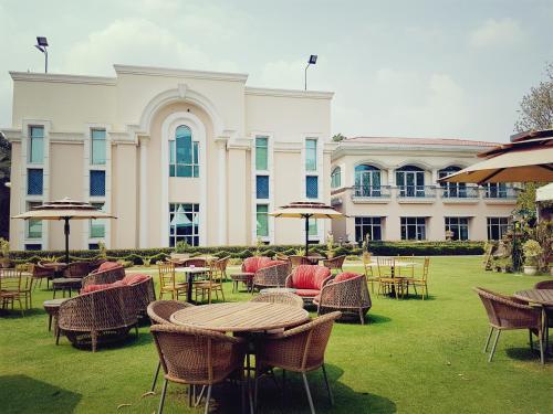 a group of tables and chairs in front of a building at The Palms Town & Country Club - Resort in Gurgaon
