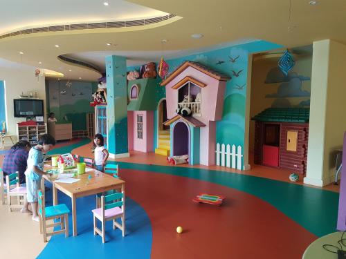 a childrens play room with a doll house and a table at The Palms Town & Country Club - Resort in Gurgaon