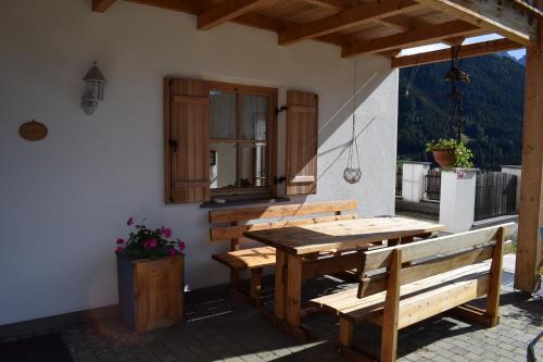 a wooden table and benches on a patio at Kellnerhof in Nova Levante