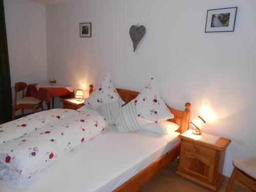 een slaapkamer met een bed met witte lakens en kussens bij Bio-Bauernhof "Hecherhof" in Thiersee