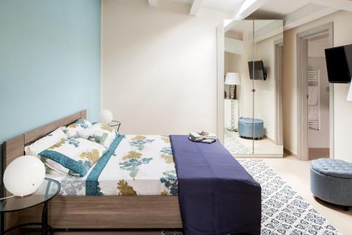 a bedroom with a bed with a blue blanket and a mirror at Scuto Home in Catania