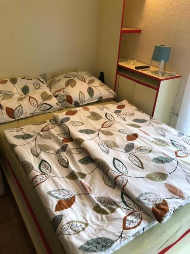 a bedroom with two beds with a blanket on it at Apartmajsko naselje Žusterna in Koper