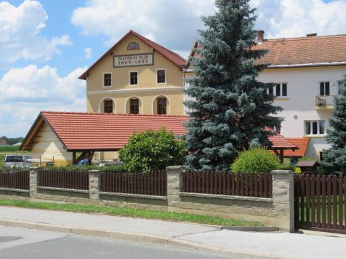 a house with a tree in front of it at Mill House Apartment and Camping in Ljutomer