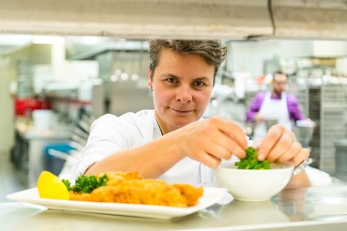 a chef eating a bowl of food with a plate of broccoli at Hotel Regina in Vienna
