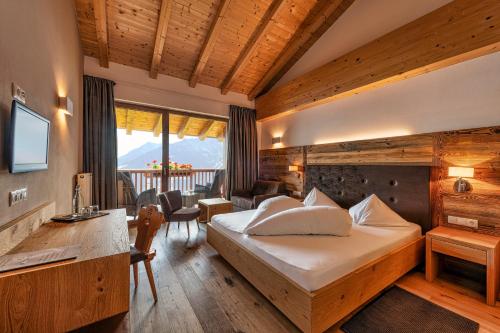 ein Hotelzimmer mit einem Bett und einem Wohnzimmer in der Unterkunft Mountain Lodge Prennanger in Schenna