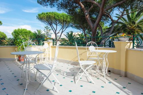 a patio with tables and chairs on a balcony at Villino Emanuele in Santa Marinella