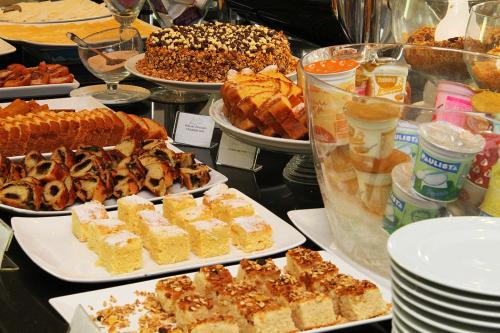 a buffet of different types of food on a table at Promenade Soho Campos dos Goytacazes in Campos dos Goytacazes
