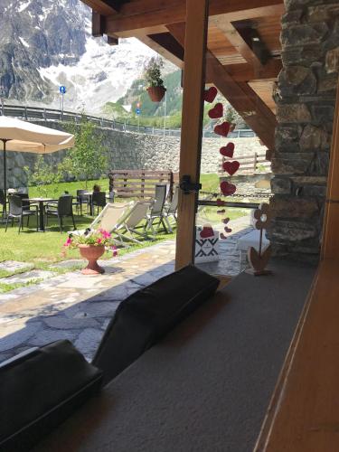 a view of a patio with chairs and a stone wall at Shatush Hotel in Courmayeur