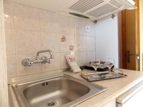 a kitchen sink with two wine glasses on a counter at Studios Kentia in Skala Marion
