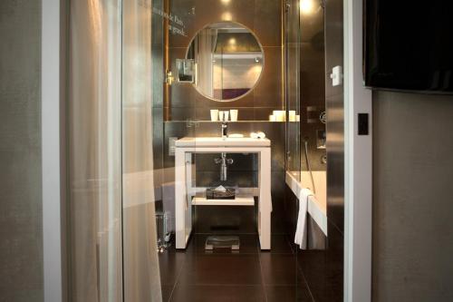 a bathroom with a sink and a mirror at Le Pavillon des Lettres in Paris