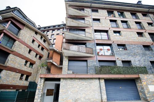 a tall brick building with windows and a balcony at Confort Escaldes HUT 5003 - HUT 7755 in Andorra la Vella