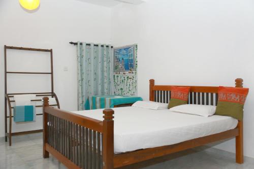 a bedroom with a wooden bed and a mirror at Omee Guest in Mirissa