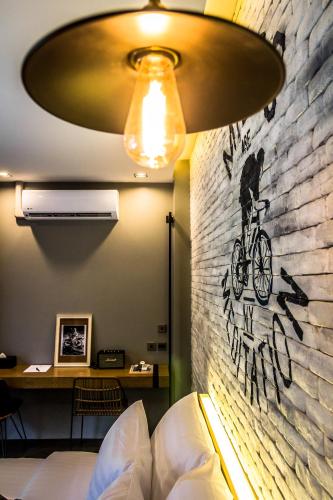 a bedroom with a brick wall with a bike on the wall at Wheeler Bed &Bike in Bangsaen