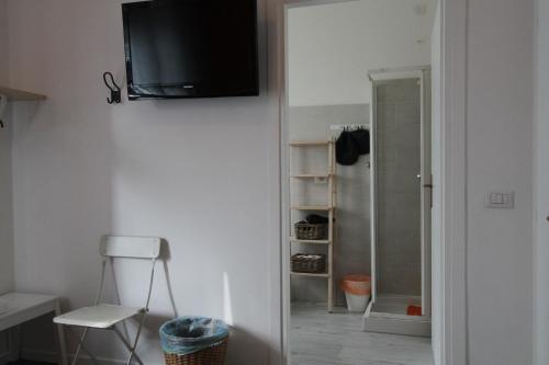 Cette chambre est dotée d'une télévision sur un mur avec une porte. dans l'établissement Soleluna Locazione Turistica, à Vérone