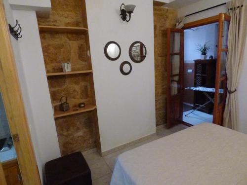 ベヘール・デ・ラ・フロンテーラにあるApartamento San Lázaroのベッド1台、棚、ドアが備わる客室です。