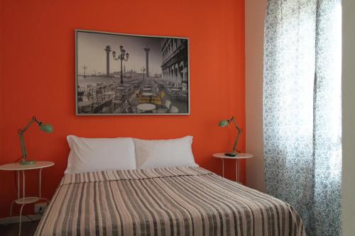 - une chambre dotée d'un lit avec un mur orange dans l'établissement Soleluna Locazione Turistica, à Vérone