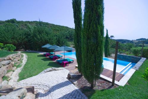 una piscina con sillas y sombrillas en un patio en Halma - Nature & Sea, en Setúbal