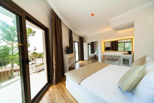 a bedroom with a large white bed and large windows at As Hotel Cesme in Çeşme